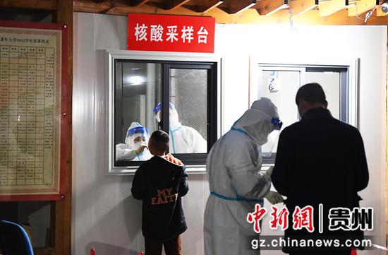 4月17日，在贵阳市南明区玉溪路片区、陈庄坝片区一核酸采样台，医护人员正在为一小朋友进行咽拭子采样。