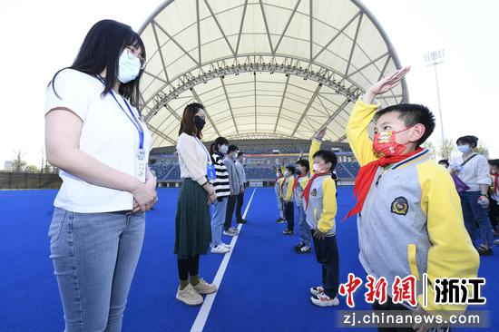 小学生们在曲棍球场向“亚运人”致敬。 王川（通讯员） 摄