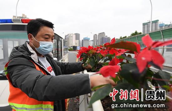 4月18日，贵阳市南明区园林绿化养护人员正在油小线立交桥上整理花箱中的鲜花。