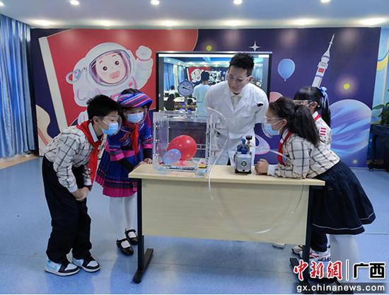 广西科技馆科技辅导员带领同学们体验《真空箱子的气球》科学实验。雷剑秋  摄