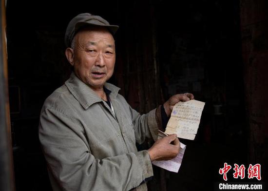 4月29日，胡光明展示自己在1976年写给父亲的保证书。　田锦泓 摄