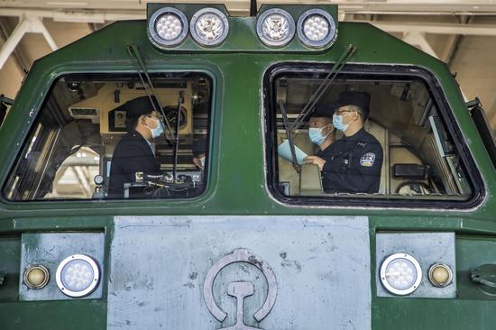 民警在火車頭內向司機講解網絡電信詐騙的知識。