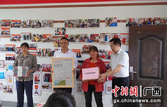 广西壮族自治区博物馆党委向织女绣娘赠送《壮锦》、《广西织绣文化》等书籍。沈婧 摄