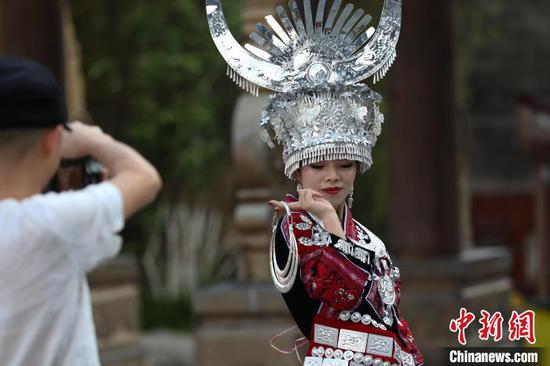 游客穿着少数民族服装在中南门历史文化旅游区拍照。　瞿宏伦 摄