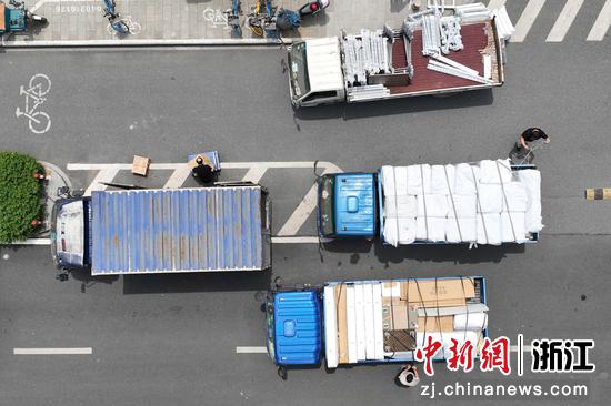 海外海商城解除“三区”管控措施后，工作人员在路边装卸货物。（无人机照片） 王刚 摄