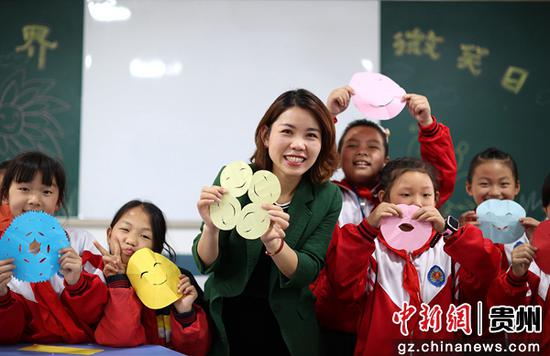 5月8日，贵州省黔东南苗族侗族自治州丹寨县城关第二小学的老师和学生在展示自己制作的笑脸卡。