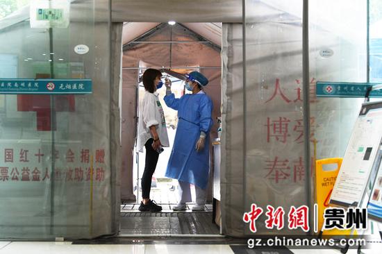 5月10日，贵阳市南明区人民医院门诊预检分诊处护士杨霞正在为前来就诊的患者测量体温。