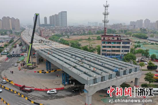 在浙江省交通集团义东高速跨东义路施工现场,随着最后一榀钢箱梁稳稳