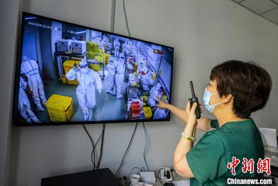 核酸实验室负责人李蕾通过监控视频及时处理实验室核心区各项事务。　刘新 摄