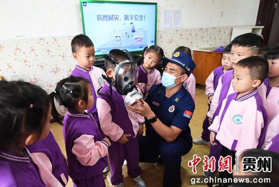 5月11日，贵阳市南明区绿苑阳光幼儿园的小朋友们在消防员的指导下学习如何使用防毒面具。3
