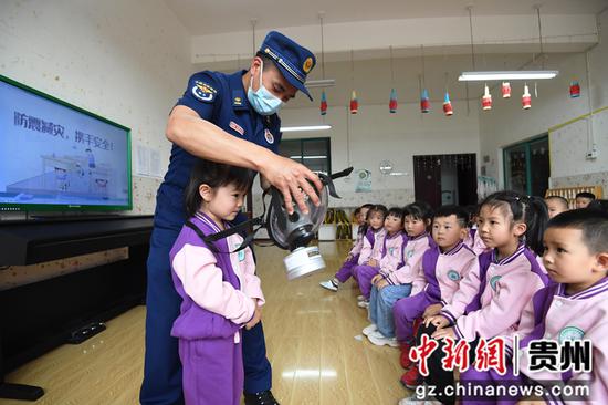 5月11日，贵阳市南明区绿苑阳光幼儿园的小朋友们在消防员的指导下学习如何使用防毒面具。