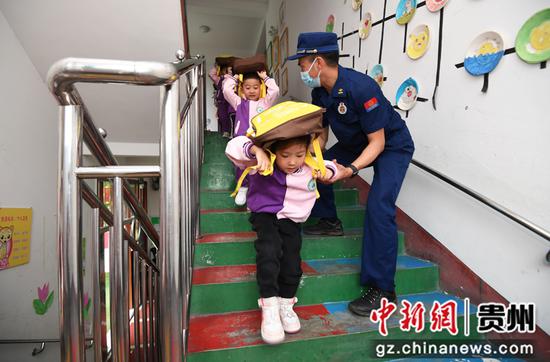 5月11日，在贵阳市南明区绿苑阳光幼儿园，小朋友们在消防员的引导下进行应急疏散演练。