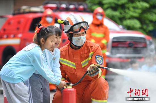 消防员教授学生使用灭火器。 黄平县消防救援大队供图