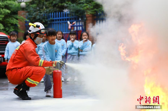 图为消防员教授学生使用灭火器。黄平县消防救援大队供图