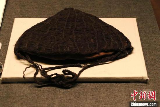 展出的距今约2800年的棕色编织帽。　苟继鹏 摄