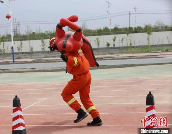 18日上午，消防救援人员在库尔勒举行400米救人疏散物资比赛。　陶拴科 摄