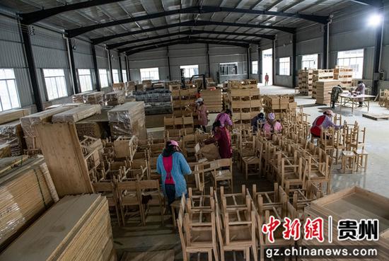 天柱县白市镇坪内村村民在厂里加工竹制桌椅。