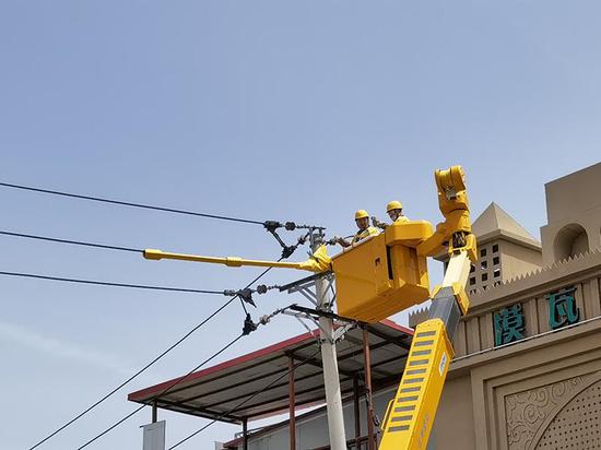 5月23日，国网乌鲁木齐供电公司抢修人员对受损线路进行临时停电处理。胡世杰摄