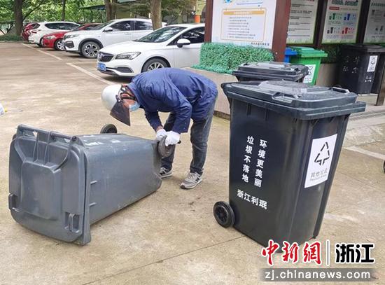 西关街道工作人员为垃圾桶更换零部件。 李淑娟 供图
