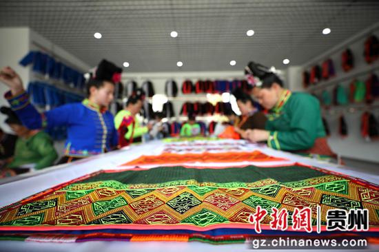 5月25日，苗族妇女在贵州省丹寨县金泉街道移民安置社区非遗手工坊做手工刺绣。