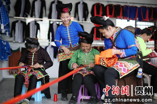 5月25日，苗族妇女在贵州省丹寨县金泉街道移民安置社区非遗手工坊交流传统手工技艺。