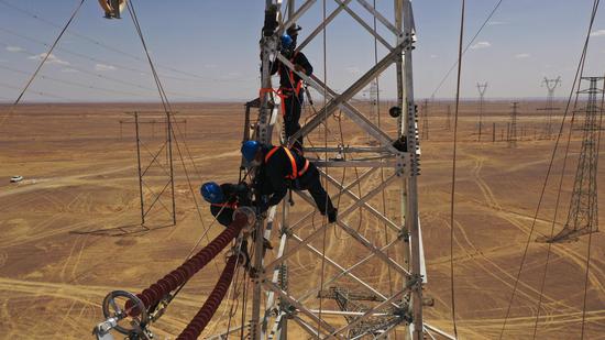 5月20日，国网哈密供电公司员工对220千伏疆木禾输电线路进行导线展放工作。冯洋 摄