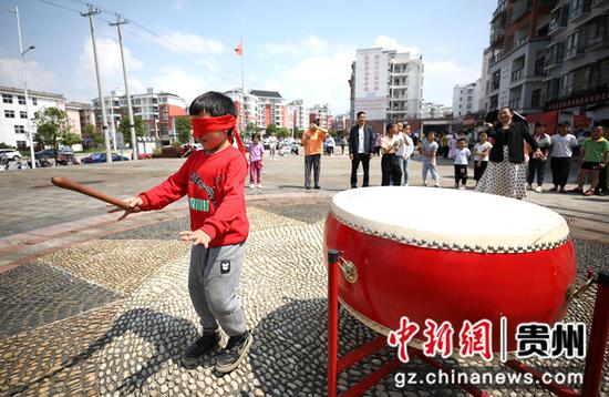 5月29日，小孩子在贵州省丹寨县金泉街道移民安置社区参加盲人摸象活动。