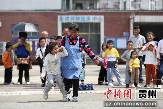 5月29日，家长与小孩子在贵州省丹寨县金泉街道移民安置社区参加绑脚赛跑活动。