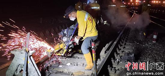 图为玉林工务段焊轨工在益湛线上进行钢轨焊缝打磨平顺作业。李慕传 摄