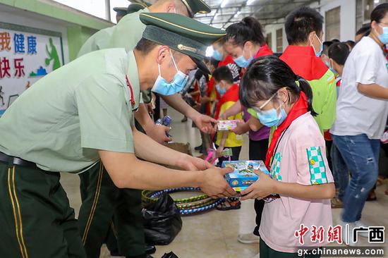武警官兵将学习用品、文体器材和零食送到孩子们手中。黄若贤 杨星 奎子清  供图