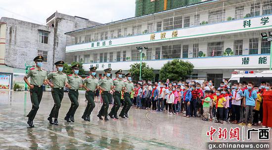 武警官兵为孩子们表演军事科目。黄若贤 杨星 奎子清  供图
