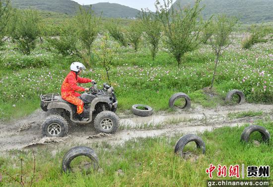 6月3日，参加自驾穿越系列活动的车友在贵州省贵阳市花溪区高坡乡石门锦绣景区花海骑行越野摩托车。