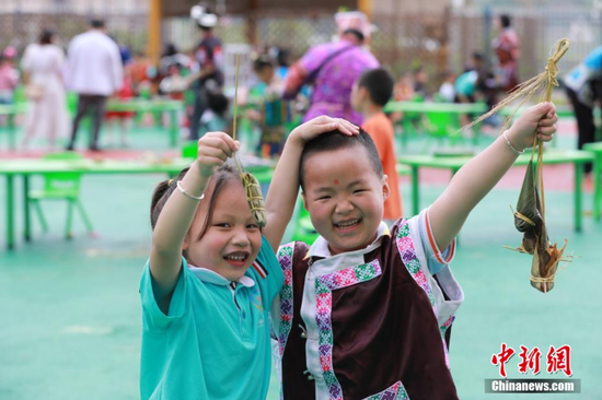 图为剑河县幸福社区中心幼儿园孩子展示刚包好的粽子。 杨家孟 摄