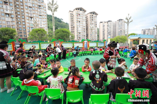 图为剑河县幸福社区中心幼儿园，家长、老师和孩子们在包粽子。 杨家孟 摄