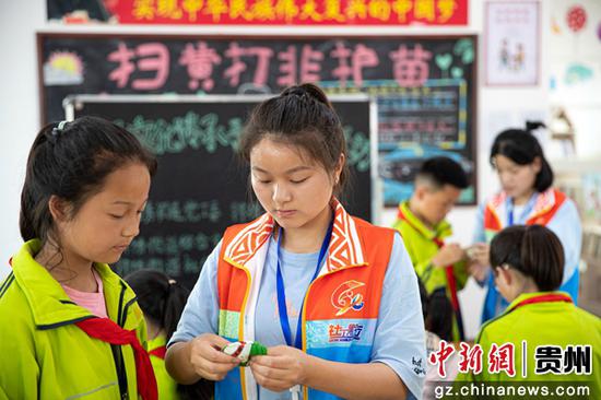 6月2日，贵州省黔西市锦绣花都易地扶贫搬迁安置点，社会工作站工作人员指导搬迁群众的孩子手工制作香包。