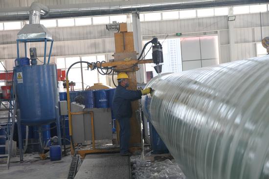 新疆亿佰钢管业科技有限公司玻璃钢管生产车间工人在忙着赶制订单。