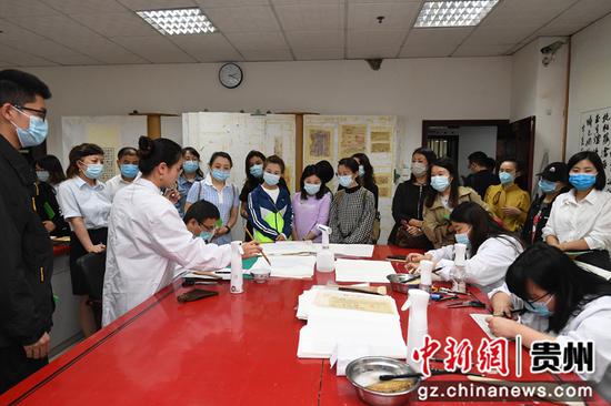 6月7日，市民在贵州省档案馆观看档案修复师修复档案。