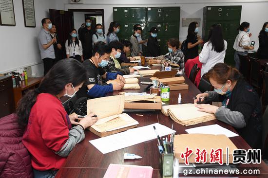 6月7日，市民在贵州省档案馆档案整理室观看工作人员整理档案。