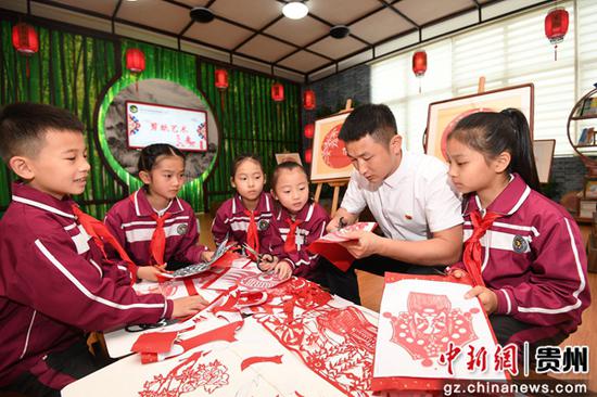 6月10日，贵州省贵阳市南明区花果园第三小学剪纸社团的学生正在老师的指导下创作剪纸作品。