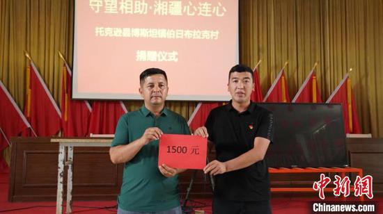 阿不都瓦尔·托合提（左）为湖南郴州捐赠抗洪救灾资金。　高双强　摄