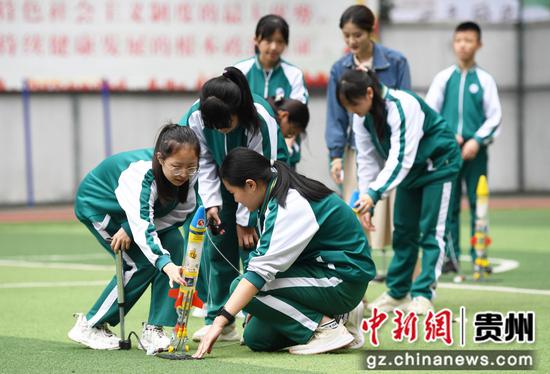 6月14日，贵阳市南明区第一实验中学的学生正用打气筒给“水火箭”加压。