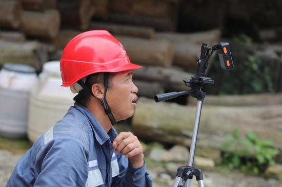 在黔东南雷山县羊排岩寨，南方电网贵州凯里雷山供电局员工利用运用数字化手段，“一键”拍摄现场施工视频上传至安全管理平台，实现安全管控“现场直播”。林世康 摄