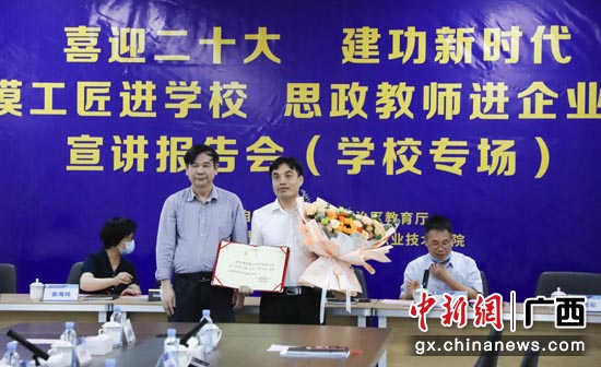 广西电职院党委书记唐春生（左）向唐劲军（右）颁发证书。韦京求 摄
