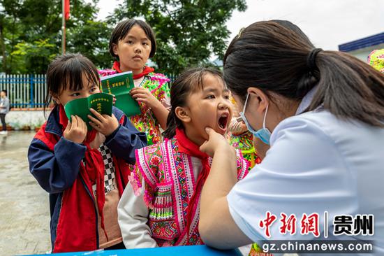 贵州省黔西市中医医院医务人员在屯江教学点给学生做健康检查。