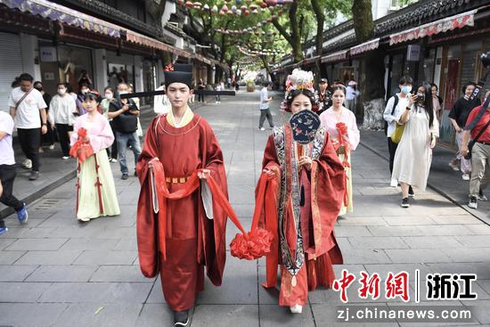 身着古装的“新人”行走在杭州中国丝绸城步行街上。 王刚供图