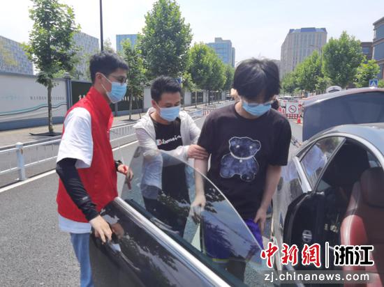 精诚志愿者正在搀扶行动不便的考生上车。苏宁鑫 摄