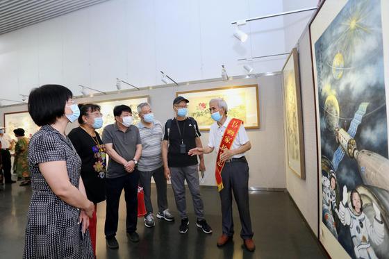 徐铁志在展览现场介绍作品《航天强国梦》。