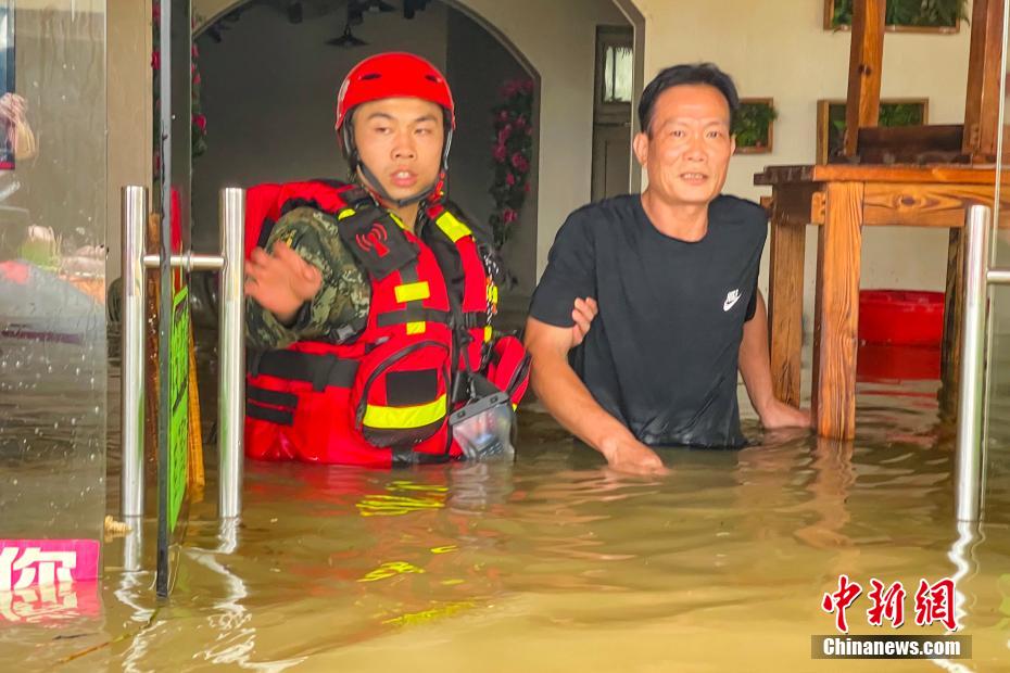 6月22日，武警官兵涉水转移受困群众。施晨洲 摄