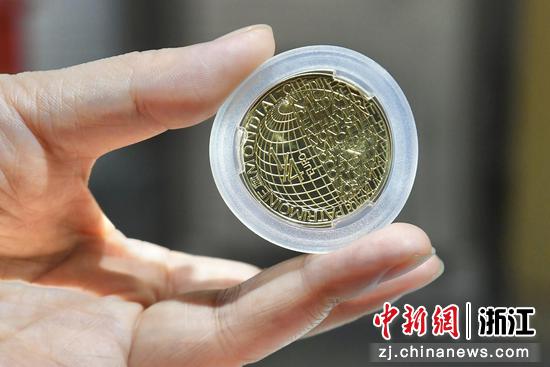 工作人员展示《世界文化遗产杭州西湖纪念币》背面。王刚 摄