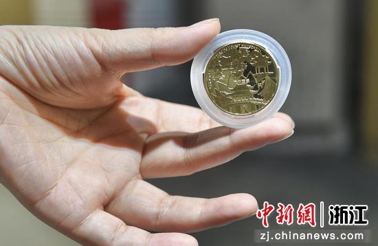 工作人员展示《世界文化遗产杭州西湖纪念币》正面。王刚 摄